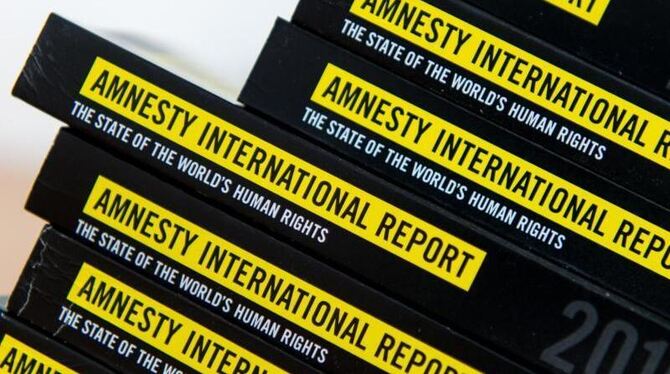 Ausgaben des Jahresberichts 2016/2017 von Amnesty International liegen in Berlin auf einem Tisch. Foto: Monika Skolimowska