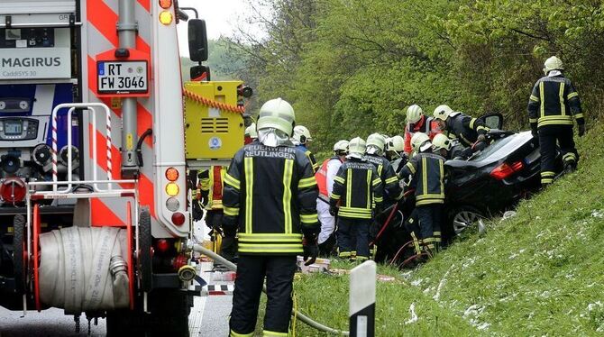 Rettungskräfte am völlig zerstörten BMW.