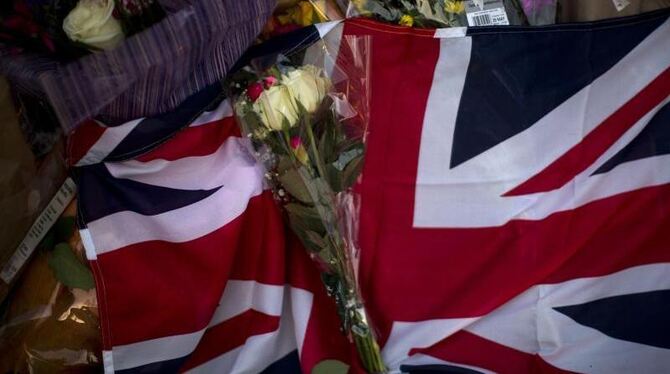 Ein Union Jack, Blumen und Kerzen liegen in Manchester nach einer Gedenkfeier auf dem Albert Square. Foto: Emilio Morenatti