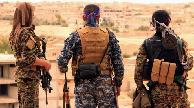 Auf der von den Syrischen Demokratischen Kräften (SDF) zur Verfügung gestellten Aufnahme stehen drei Kämpfer der SDF in Tabqa