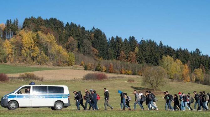 Flüchtlinge gehen im November 2015 nahe Wegscheid in Oberbayern nach der Überquerung der Grenze hinter einem Polizeifahrzeug