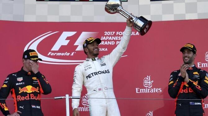 Lewis Hamilton freut sich nach seinem Sieg mit den Red Bull-Fahrern Max Verstappen (l) und Daniel Ricciardo. Foto: Toru Takah
