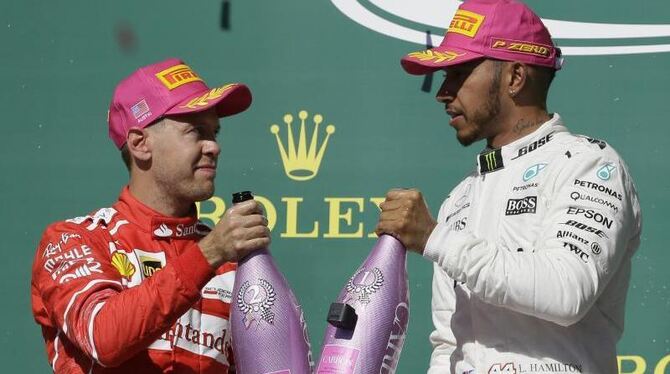 Sebastian Vettel stößt mit Lewis Hamilton bei der Siegerehrung in Austin an. Foto: Tony Gutierrez