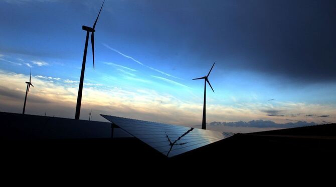 Dunkle Regenwolken ziehen bei Westheim über einer Solarkraftanlage und drei Windrädern. Foto: Karl-Josef Hildenbrand