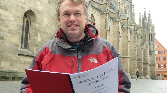 Torsten Wille mit dem Klavierauszug seiner Kantate vor der Marienkirche.