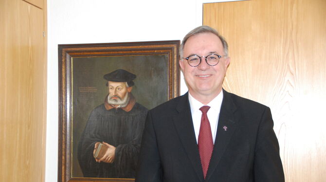 Bischof Frank Otfried July in seinem Stuttgarter Amtszimmer neben einem Porträt des Reformators Johannes Brenz. FOTO: SCHÜRER