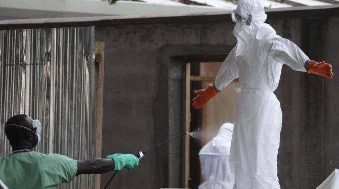 In einem Krankenhaus im liberianischen Monrovia wird eine Schwester desinfiziert. Auch Nigeria sucht nach möglichen Infiziert
