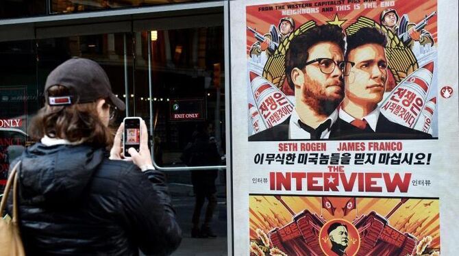 Vor einem Kino in  New York fotografiert eine Frau das Filmplakat von »The Interview«. Foto: Justin Lane
