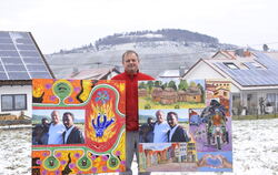 Der Neuhäuser Bäckermeister Michael Winter mit zwei Bildern, die ihn mit drei Afrikanern zeigen: Die Bilder sind für die Ausstel