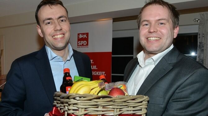 Sebastian Weigle (rechts) gratuliert Nils Schmid mit einem Geschenkkorb voller Energiespendern zur Nominierung als Landtagskandi