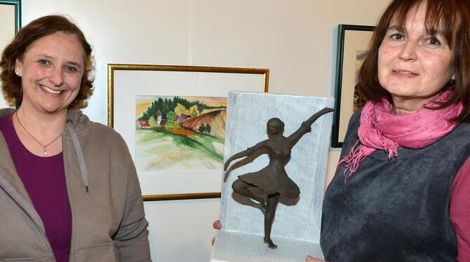 Anette Reiff (links) neben ihrem Werk »Dorf im Feld«, Margarete Högermeyer hält eine ihrer Skulpturen in den Händen: »Balance«.