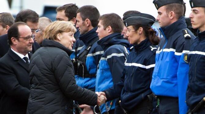 Kanzlerin Merkel und Frankreichs Präsident Hollande begrüßen in Seyne Les Alpes Bergrettungskräfte der französischen Polizei.