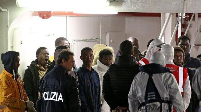 Italienische Ermittler und gerettete Flüchtlinge an Bord im Hafen von Catania auf Sizilien. Foto: Alessandro di Meo