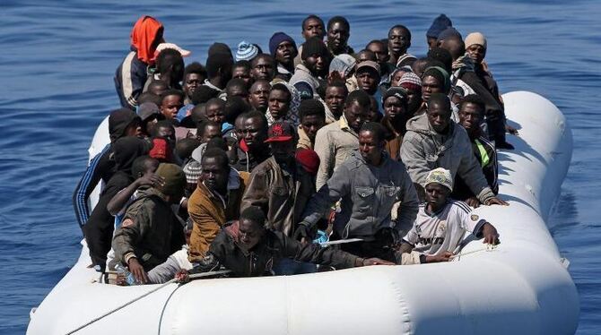 Im Mittelmeer wird ein Boot mit afrikanischen Flüchtlingen von der italienischen Küstenwache abgeschleppt. Foto: Alessandro d