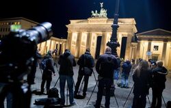 Frühaufsteher fotografieren am Brandenburger Tor in Berlin die Mondfinsternis. Foto: Kay Nietfeld