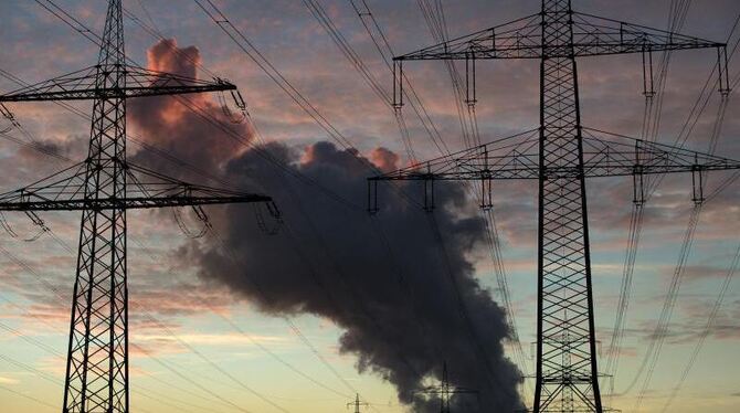 Dunkle Dampf- und Rauchwolken eines Kraftwerks am Himmel. Foto: Federico Gambarini/Illustration