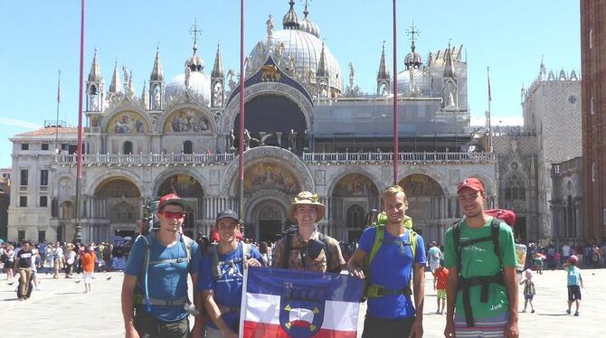 Die fünf Abiturienten aus Pfullingen mit der Stadtflagge am Ziel ihrer mehrwöchigen Wanderung: dem Markusplatz in Venedig. FOTO: