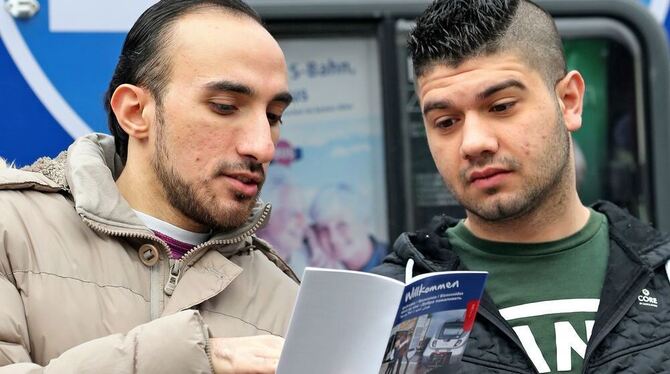 Wie der ÖPNV funktioniert: Flüchtlinge lesen einen Flyer des Verkehrsbundes. FOTO: DPA