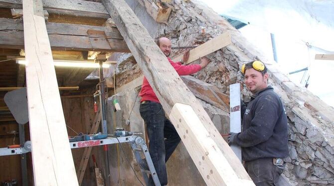 Die Restauratoren Tobias Luippold und Sven Förster (rechts) haben auf dem Dach des Stadtschlosses einen maroden Balken ausgebaut