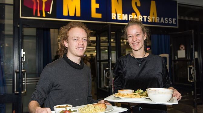 Jonathan Frey und Carlotta Krone halten in Freiburg Tabletts mit Essen. Das Essen hatten andere Studenten in der Mensa nicht auf