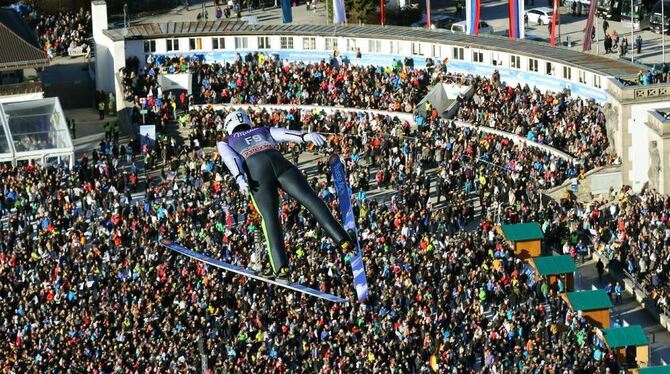 Der Vorspringer mit der Startnummer F9:  Nico Haydt  segelt beim Neujahrsspringen über der Arena von Garmisch-Partenkirchen, run