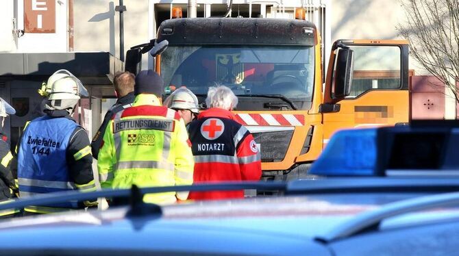 Einsatzkräfte von Rettungsdienst, Feuerwehr und Polizei stehen an einer Unfallstelle in Zwiefalten. Das Fahrzeug eines Müllentso