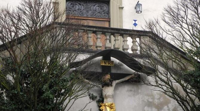 Ein Kruzifix hängt vor dem Portal der Stadtkirche von Arnstein. Das 8000-Einwohner-Städtchen versucht mit dem tragischen Vorf