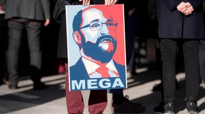 Ein SPD-Parteianhänger hält in Berlin ein Plakat mit einem Bild von Martin Schulz. Foto: Kay Nietfeld