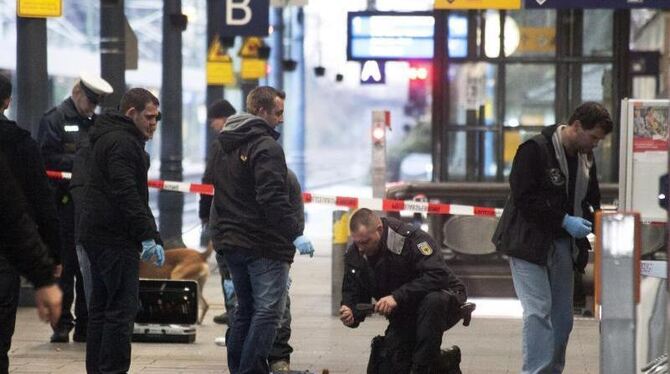 Sprengsatz an Gleis 1: Polizisten untersuchen am 10.12.2012 am Hauptbahnhof in Bonn die Reste einer Tasche. Foto: Meike Bösch