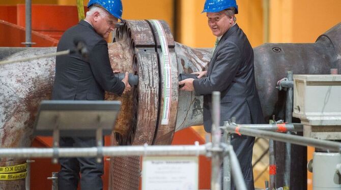 Der Technikvorstand der EnBW AG, Hans-Josef Zimmer (l) und der baden-württembergische Umweltminister Franz Untersteller schraube