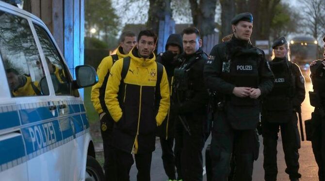 Spieler von Borussia Dortmund und Polizisten stehen in Dortmund vor einem Hotel. Foto: Ina Fassbender