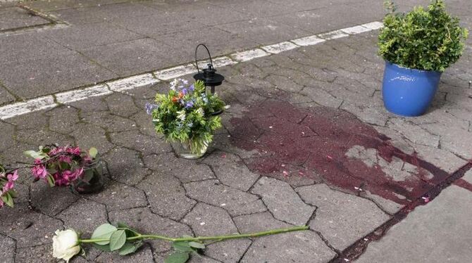 Blumen liegen auf einem Gehweg in Hannover. Eine junge Frau starb offenbar an einem Gewaltverbrechen. Foto: Peter Steffen