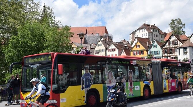 Bilder von typischen Passagieren prangen außen auf dem Fahrzeug:  Der »Kunstbus« beim Halt auf der Neckarbrücke.