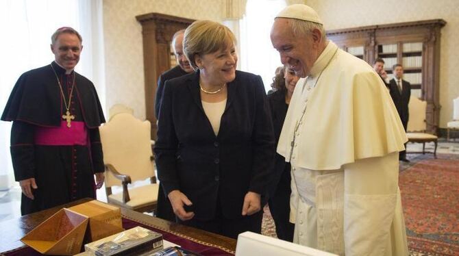 Papst Franziskus und Bundeskanzlerin Angela Merkel tauschen Geschenke aus. Foto: Guido Bergmann