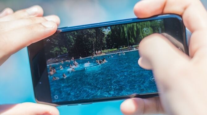 Das Smartphone als Kamera: Ein diskreter kurzer Klick macht heimliches  Fotografieren einfach und zum Thema für die Freibadbetre