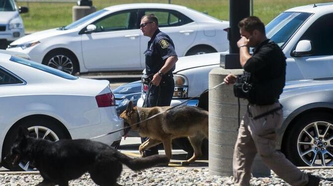 Polizisten mit Hunden untersuchen am Bishop International Airport in Flint im US-Bundesstaat Michigan die Tatortumgebung. Fot