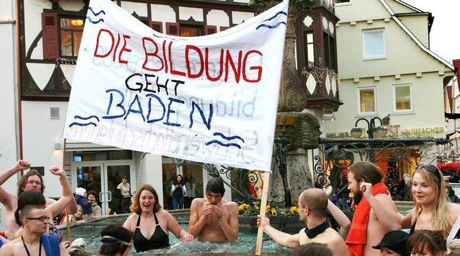 Erst im Schweinsgalopp über den Weihnachtsmarkt, dann Bad im Marktbrunnen: Studenten protestieren im Badeanzug. GEA-FOTO: HD