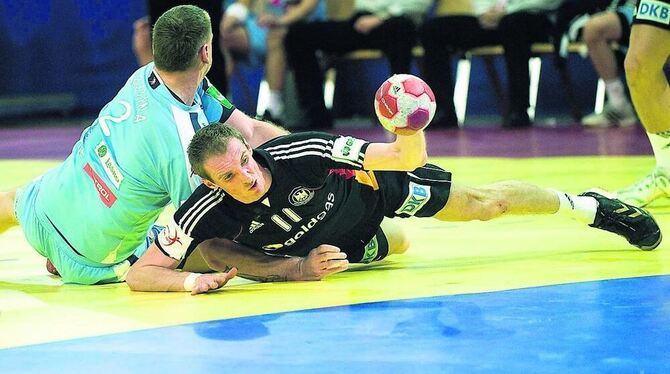 Holger Glandorf durch ein Foul gebremst: Kampf war Trumpf im Spiel der deutschen Mannschaft gegen Slowenien. FOTO: AP