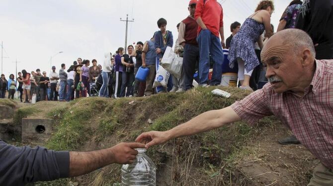 Helfer verteilen sauberes Wasser an Chilenen.