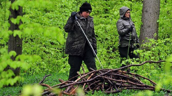 Polizisten suchen im Wald nach Spuren der Entführten.