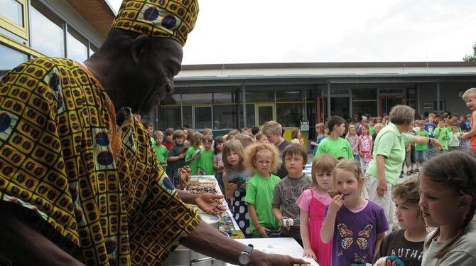 Guten Appetit wünscht Kobna Anan jedem der 120 Kinder zum Festmahl und reicht Joloff, das traditionelle Essen aus Ghana, das in