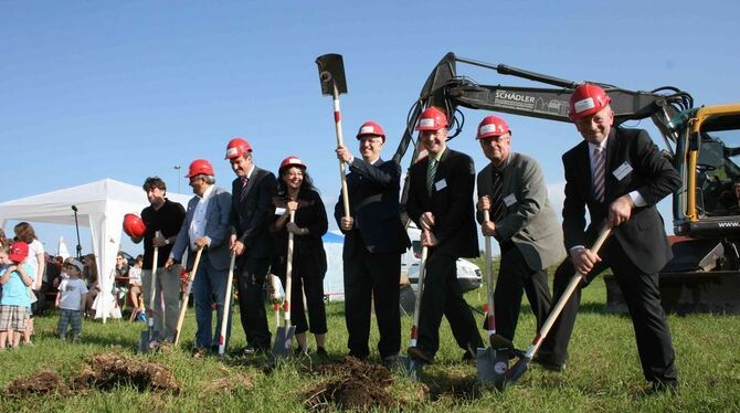 An den Spaten: Apostel Volker Kühnle mit erhobenem Spaten mit Projektleiterin, Gemeindevorsteher und Architekt. FOTO: DÜRR