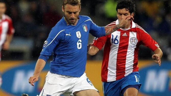 Der Italiener de Rossi (l) spielt einen Pass vor Paraguays Cristian Riveros.