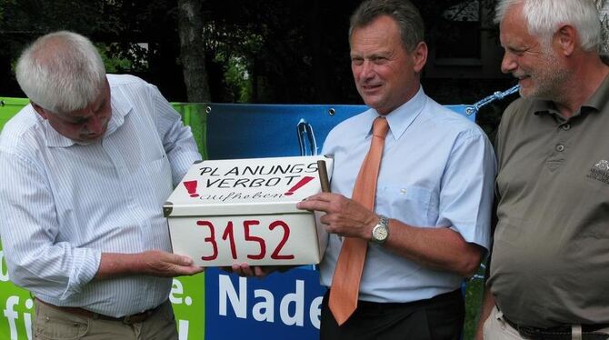 Hans Gerstenmaier (links) und Gerd Recht (rechts) von der Bürgerinitiative übergeben Bürgermeister Helmut Knorr ein gewichtiges