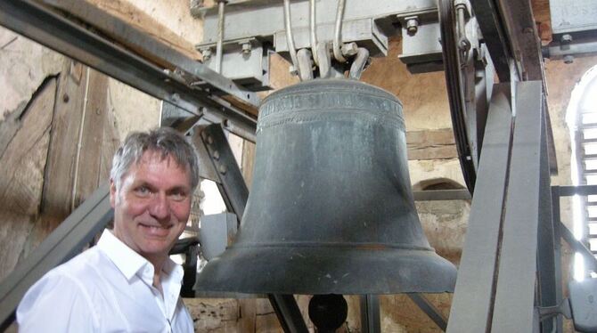 Pfarrer Eberhard Seybold mit der fünfhundert Jahre alten Mehrstetter Taufglocke. FOTO: RÖSSLE