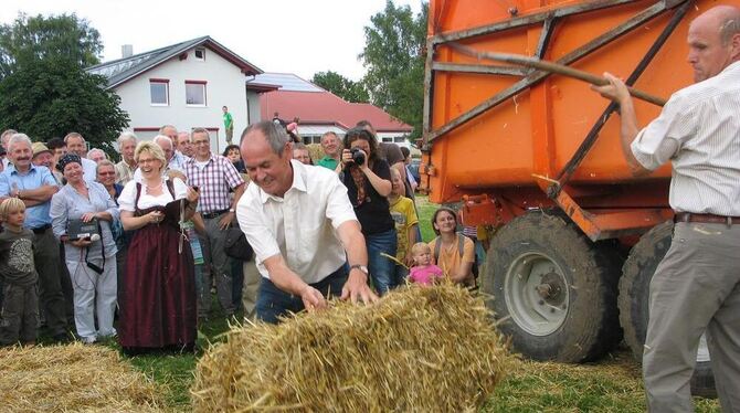 Teamwork mit Spaßfaktor. Landwirtschaftsminister Rudolf Köberle legt die Strohballen vor, Karl-Wilhelm Röhm gabelt.