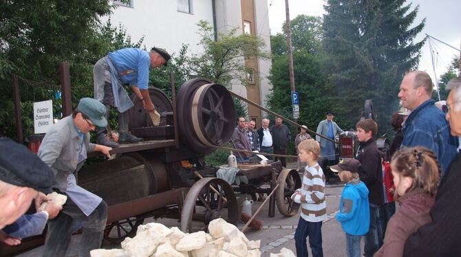 Gewaltige Kalkbrocken werden zu Kies und Sand: Günther Schwenkel (auf dem Wagen) arbeitet mit Gehilfen an der Steinquetsche. FOT