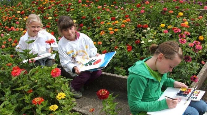 Johanna, Rosa und Luise setzen sich zum Malen mitten ins Zinienbeet der Mariaberger Gärtnerei. FOTO: HÄUSSLER