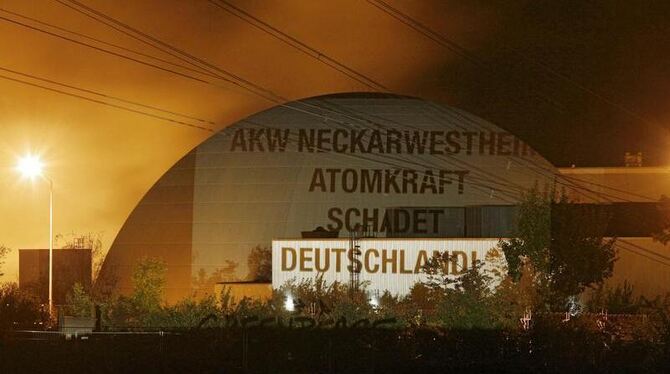 Der Spruch »AKW Neckarwestheim: Atomkraft schadet Deutschland« ist in Neckarwestheim auf das Reaktorgebäude des AKW Neckarwes