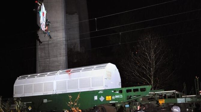 Zwei Aktivisten hängen nahe dem nordhessischen Morschen von einer rund 70 Meter hohen Brücke über dem Castortransport. 